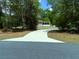 View of the home with screened in porch and long driveway on a wooded lot at 20386 Sw 95Th St, Dunnellon, FL 34431