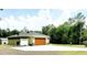 The exterior of the home showcases a large parking area, a well-maintained yard, and mature trees at 20386 Sw 95Th St, Dunnellon, FL 34431