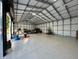 Large garage interior featuring durable flooring, ample space, and overhead metal beam construction at 20386 Sw 95Th St, Dunnellon, FL 34431