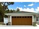 A large garage with a decorative door and stone accents complements the home's exterior at 20386 Sw 95Th St, Dunnellon, FL 34431