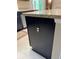 Close up of the kitchen island with neutral granite countertop and black cabinets at 20386 Sw 95Th St, Dunnellon, FL 34431