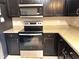 Close-up of modern range/oven, dark cabinets and granite countertop at 20386 Sw 95Th St, Dunnellon, FL 34431