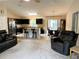 Open living area with stainless steel appliances, island seating, dining table, and comfortable furniture at 20386 Sw 95Th St, Dunnellon, FL 34431