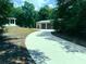 View of outbuilding with multi-car garage and circular driveway, on a wooded lot at 20386 Sw 95Th St, Dunnellon, FL 34431