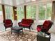 Well-lit sunroom with wicker furniture, large windows, and a patterned rug on tile floors at 20386 Sw 95Th St, Dunnellon, FL 34431