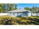 A view of the light blue house featuring a sliding glass door and a fenced backyard with green grass at 20812 Sw Cardinal Ave, Dunnellon, FL 34431
