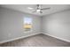 Cozy bedroom with a window, ceiling fan, and gray wood-look flooring at 20812 Sw Cardinal Ave, Dunnellon, FL 34431