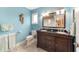 Blue bathroom with granite countertop, dual sinks, tile floors and modern fixtures at 20921 Sw 36Th St, Dunnellon, FL 34431