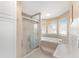 Bright bathroom featuring a walk-in shower, soaking tub, and windows that bring in natural light at 20921 Sw 36Th St, Dunnellon, FL 34431
