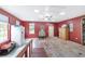 Large bonus room with terracotta tile flooring, a ceiling fan, bright windows, and charming red-painted walls at 20921 Sw 36Th St, Dunnellon, FL 34431