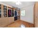 Walk-in closet featuring custom shelving, drawers, hardwood floors, and ample storage space at 20921 Sw 36Th St, Dunnellon, FL 34431