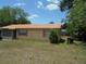 A cozy home featuring a metal roof, tan exterior, and a well-maintained front yard on a sunny day at 2912 Ne 24Th Ct, Ocala, FL 34479