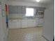 A clean kitchen featuring white appliances, cabinets, and tile flooring with a large window above the sink at 2912 Ne 24Th Ct, Ocala, FL 34479