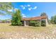 Inviting single-story home featuring a unique terracotta-tiled roof, complemented by lush green shrubbery and a spacious yard at 347 Oak Lane Dr, Ocala, FL 34472