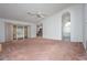 Spacious living room featuring sliding glass doors, ceiling fan, and arched doorway at 347 Oak Lane Dr, Ocala, FL 34472