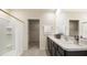 Clean bathroom featuring a double vanity, framed mirror and a walk-in shower with a glass door at 357 Hickory Course Trl, Ocala, FL 34472