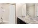Well-lit bathroom featuring a double vanity, framed mirror and a shower-tub combo with white curtain at 357 Hickory Course Trl, Ocala, FL 34472