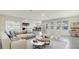 Open-concept living room with neutral tones and large windows, seamlessly connecting to the kitchen and dining area at 357 Hickory Course Trl, Ocala, FL 34472