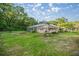 Large backyard featuring a screened-in pool and lush landscaping with a firepit at 3579 Sw Shorewood Dr, Dunnellon, FL 34431