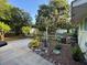 Landscaped backyard featuring lush gardens, mature trees, a fence, and outbuildings at 3579 Sw Shorewood Dr, Dunnellon, FL 34431
