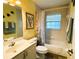Bright bathroom with vanity and neutral-colored tile features a shower-tub combo and decorative accents at 3579 Sw Shorewood Dr, Dunnellon, FL 34431
