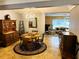 Bright dining room with chandelier, wooden hutch, and a view into the adjacent sunny living area at 3579 Sw Shorewood Dr, Dunnellon, FL 34431
