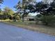 Front exterior of the home on a well-manicured lawn with mature trees at 3579 Sw Shorewood Dr, Dunnellon, FL 34431