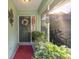 Charming front porch with decorative wreath, plants, and a red mat at 3579 Sw Shorewood Dr, Dunnellon, FL 34431
