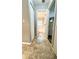 Hallway with neutral tile flooring connects to a bathroom with shower-tub combo and to another room at 3579 Sw Shorewood Dr, Dunnellon, FL 34431