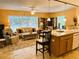 Cozy living area with large windows, comfortable seating, and an adjacent kitchen with breakfast bar at 3579 Sw Shorewood Dr, Dunnellon, FL 34431