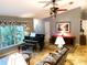 Cozy living room featuring a grand piano, floral furnishings, and natural light from a large window at 3579 Sw Shorewood Dr, Dunnellon, FL 34431