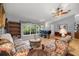 Comfortable living room featuring a piano and natural light from a large window at 3579 Sw Shorewood Dr, Dunnellon, FL 34431