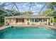 Back of house with a screened-in pool and sun deck, great for entertaining and relaxing at 3579 Sw Shorewood Dr, Dunnellon, FL 34431