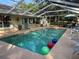 Inviting screened-in pool area with chairs, outdoor seating, and colorful floating balls at 3579 Sw Shorewood Dr, Dunnellon, FL 34431