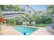 Screened-in pool area with lounge chairs and outdoor seating; landscaped backyard at 3579 Sw Shorewood Dr, Dunnellon, FL 34431