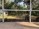 View from the screened patio, showcasing the expansive yard and lush greenery, providing a serene outdoor living space at 3579 Sw Shorewood Dr, Dunnellon, FL 34431