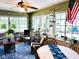 Bright sunroom filled with plants, wicker furniture, and an American flag adding a patriotic touch at 3579 Sw Shorewood Dr, Dunnellon, FL 34431