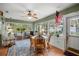 Bright sunroom featuring large windows, tile flooring, and a cozy seating area with an American flag at 3579 Sw Shorewood Dr, Dunnellon, FL 34431