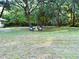 A peaceful seating area invites relaxation and enjoyment amidst the natural beauty of the landscaped homesite at 3579 Sw Shorewood Dr, Dunnellon, FL 34431