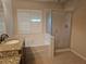 Bathroom showcasing granite counters, single sink vanity, soaking tub with shower, and modern shutters at 3918 Sw 57Th Ave, Ocala, FL 34474