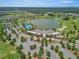 Scenic aerial view showcasing a lake, pool, clubhouse, and golf course within a vibrant residential community at 4411 Nw 53Rd Ct, Ocala, FL 34482