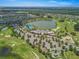 Expansive aerial view featuring a large lake, community pool, golf course, and clubhouse amidst lush greenery at 4411 Nw 53Rd Ct, Ocala, FL 34482