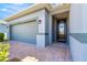 A front view of the garage and entryway with a brick walkway and stucco siding at 4411 Nw 53Rd Ct, Ocala, FL 34482