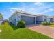 A low angle view of the home's garage and brick driveway, showcasing the well-kept lawn at 4411 Nw 53Rd Ct, Ocala, FL 34482