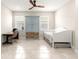 Neutral tiled living space with a blue cabinet, white daybed, and ceiling fan at 4411 Nw 53Rd Ct, Ocala, FL 34482