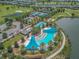 Aerial view of resort-style pool with cabanas, palm trees, and lake access at 4411 Nw 53Rd Ct, Ocala, FL 34482