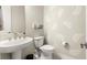 Stylish powder room featuring a pedestal sink, a toilet, and decorative wall stencils at 4411 Nw 53Rd Ct, Ocala, FL 34482
