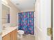 Bathroom featuring a single sink vanity, toilet, mirror and a Spiderman-themed shower curtain at 4624 Se 32Nd Pl, Ocala, FL 34480