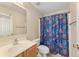 Neutral bathroom featuring a single sink vanity, toilet, mirror, and a Spiderman themed shower curtain at 4624 Se 32Nd Pl, Ocala, FL 34480