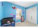 Bedroom features blue walls, double closet, window, and neutral carpet, creating a playful and versatile space at 4624 Se 32Nd Pl, Ocala, FL 34480